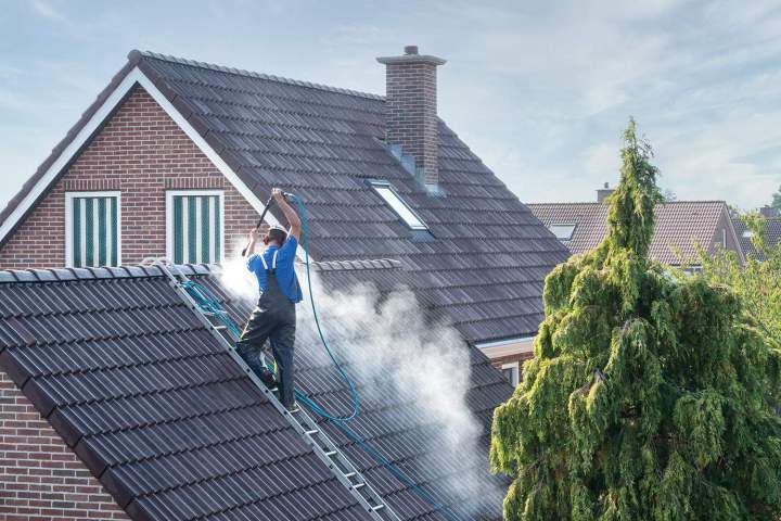 Couvreur nettoyant une toiture à Ferrières-en-Bray